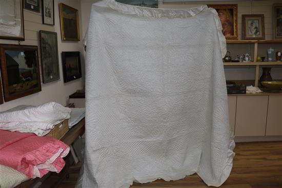 An off-white quilt with blue stitching, a reversible blue and cream quilt, a creamy oyster quilt and a mint green quilt (4)